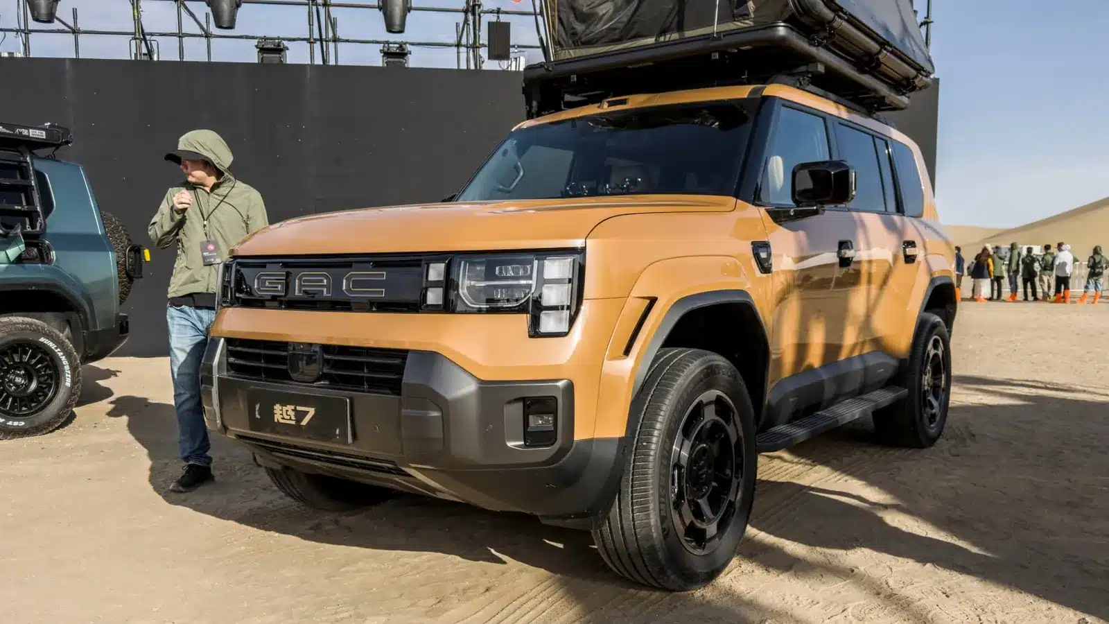 GAC Yue 7 สีเหลืองจัดแสดงในงาน มีผู้ชมยืนดูอยู่ด้านข้างรถ