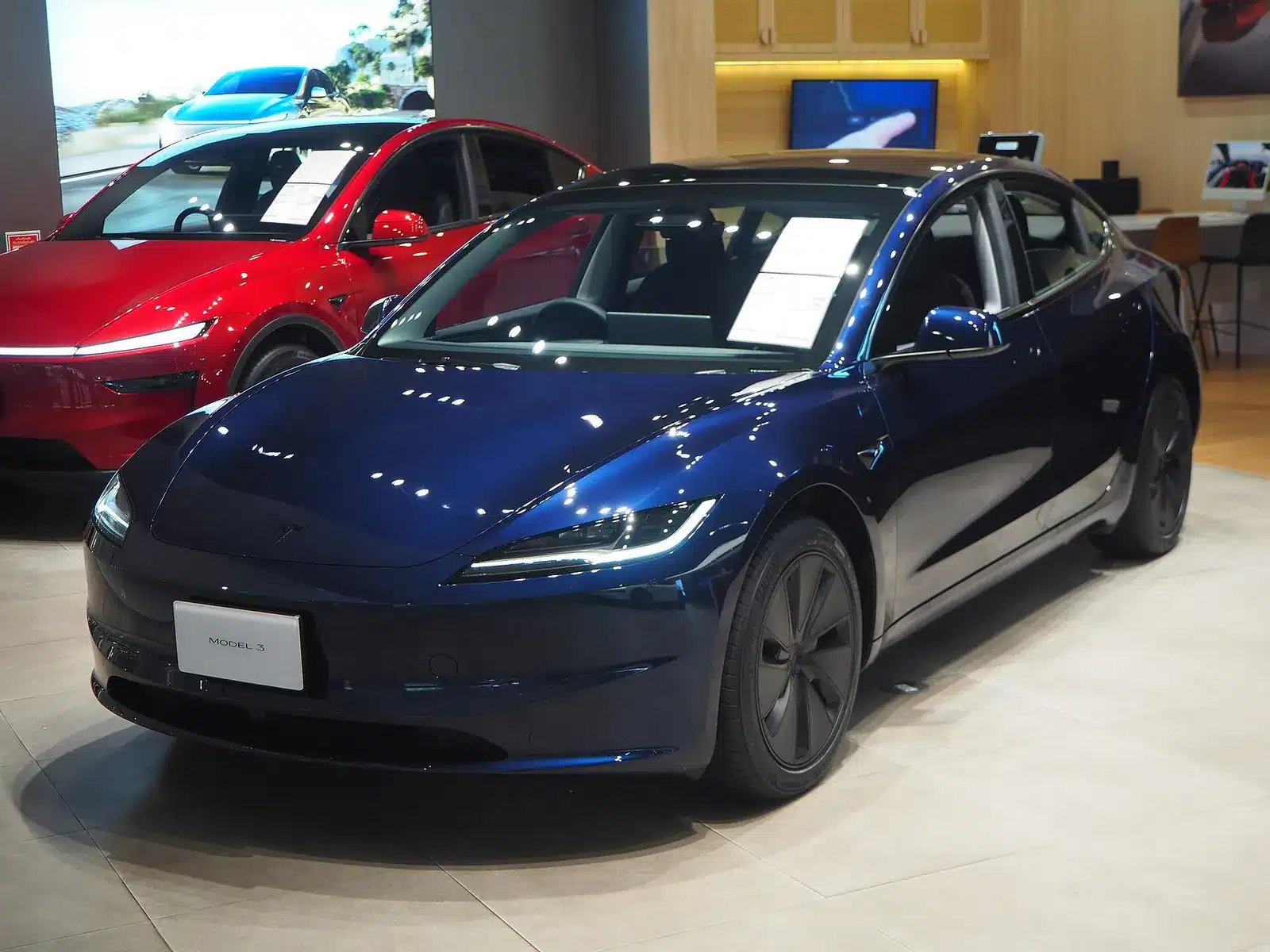 Tesla Model 3 สีน้ำเงินมุมหน้าสามส่วนสี่ในโชว์รูม