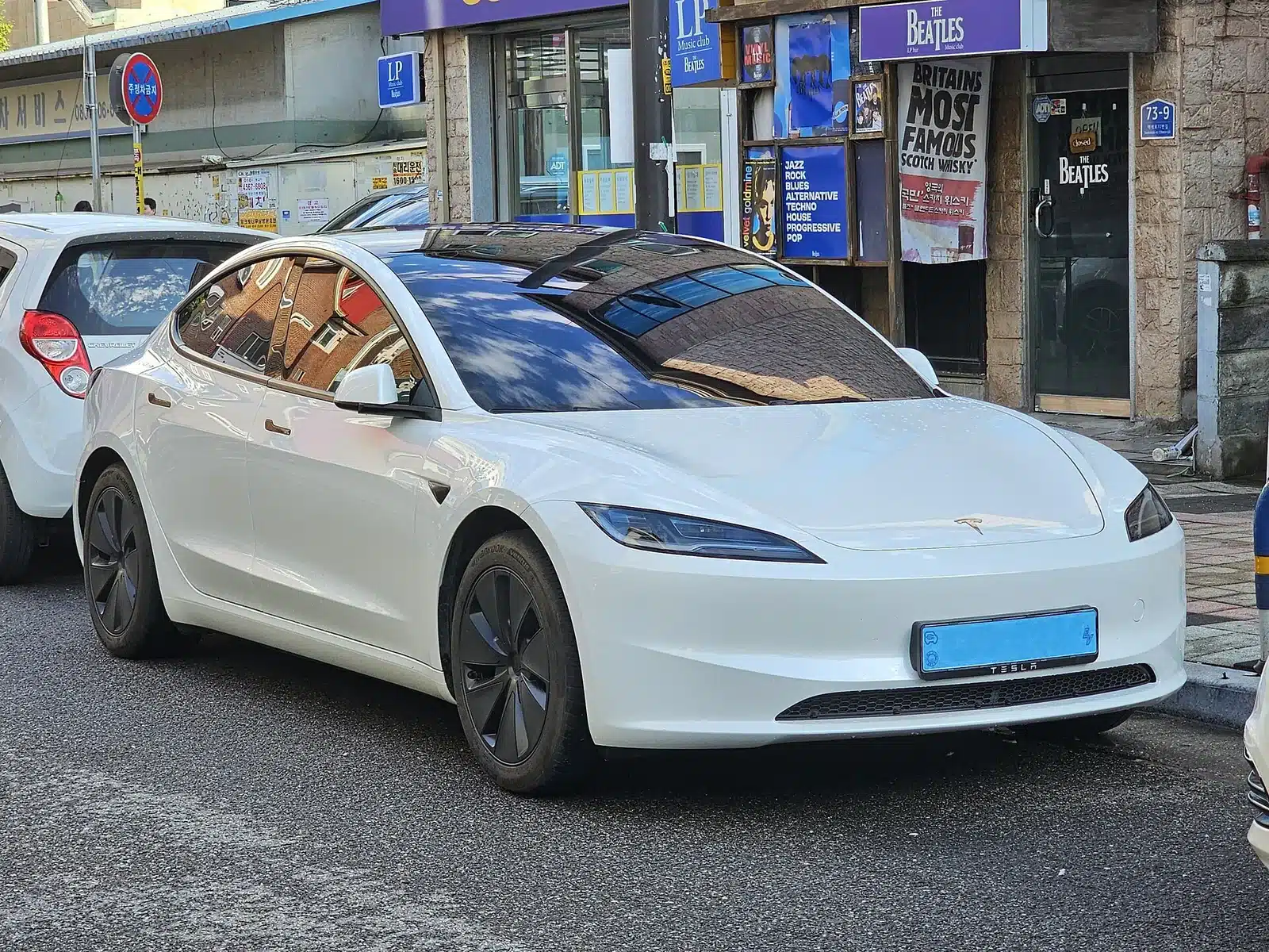 Tesla Model 3 สีขาวมุมด้านข้างเต็มคัน